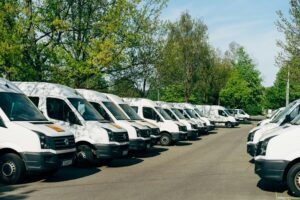 Mehrere Firmenwagen auf einem Parkplatz veranschaulichen den Fahrerkreis einer Firmenflotte.