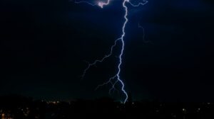 Blitzeinschlag bei Nacht als Symbol für Risiken beim Gewerbeimmobilie versichern.