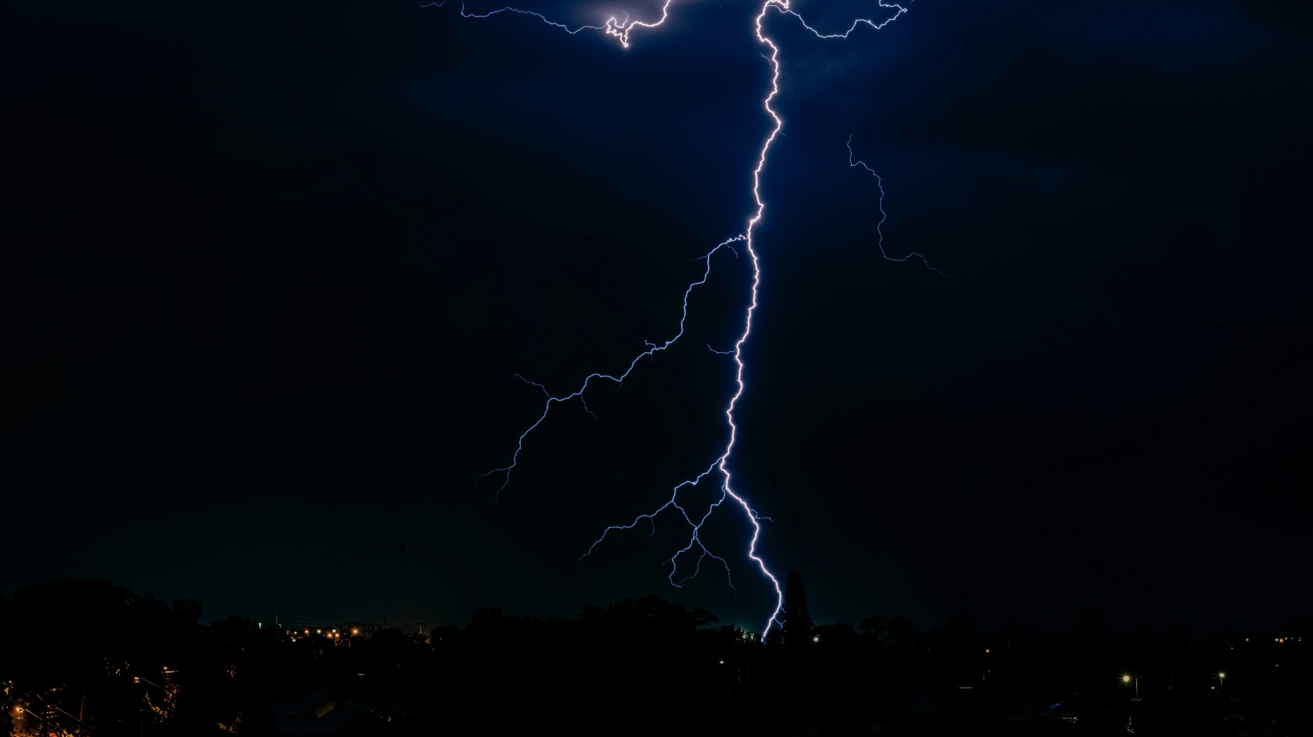 Blitzeinschlag bei Nacht als Symbol für Risiken beim Gewerbeimmobilie versichern.
