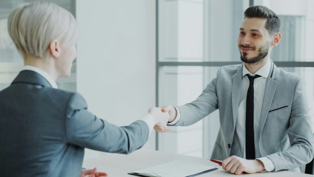 Arbeitgeber und Arbeitnehmer besiegeln eine Vereinbarung als Symbol für ein modernes Arbeitgeberversprechen.