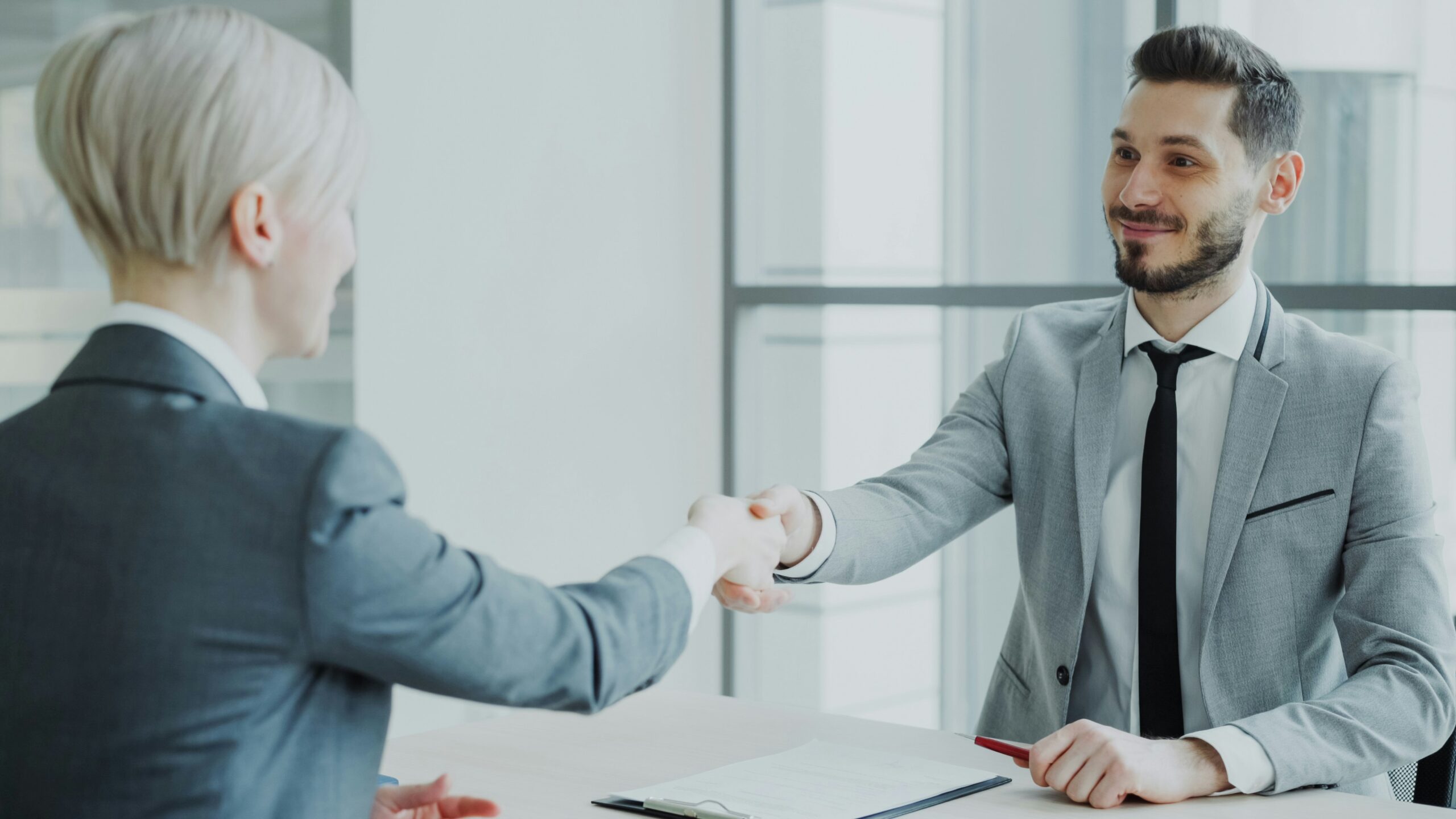 Arbeitgeber und Arbeitnehmer besiegeln eine Vereinbarung als Symbol für ein modernes Arbeitgeberversprechen.